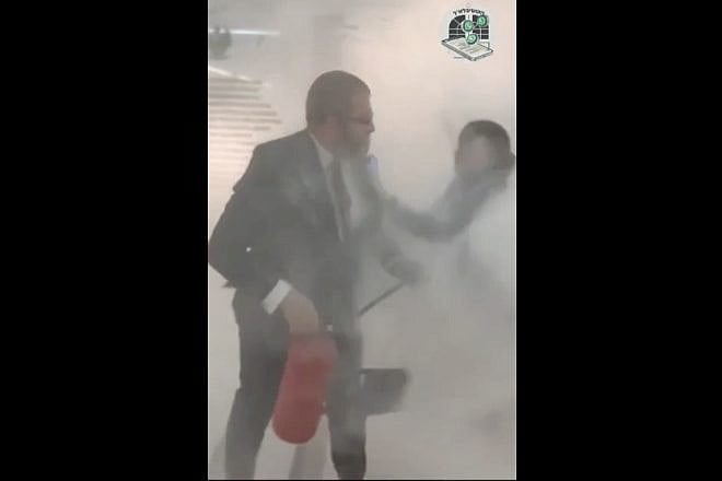 A far-right member of Poland’s Parliament, Grzegorz Braun, extinguishes a Chanukah menorah (injuring a woman) on Dec. 12, 2023. Credit: Chabad of Poland.